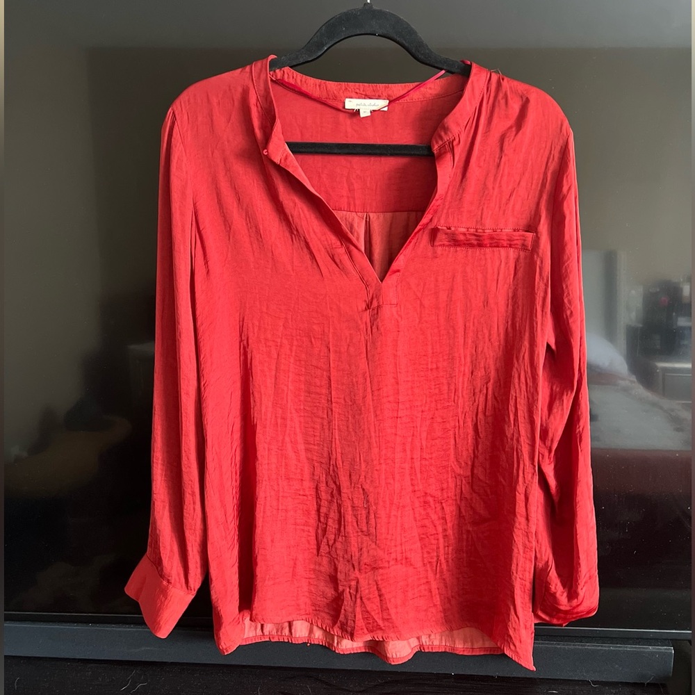Long-sleeved brick-colored blouse.